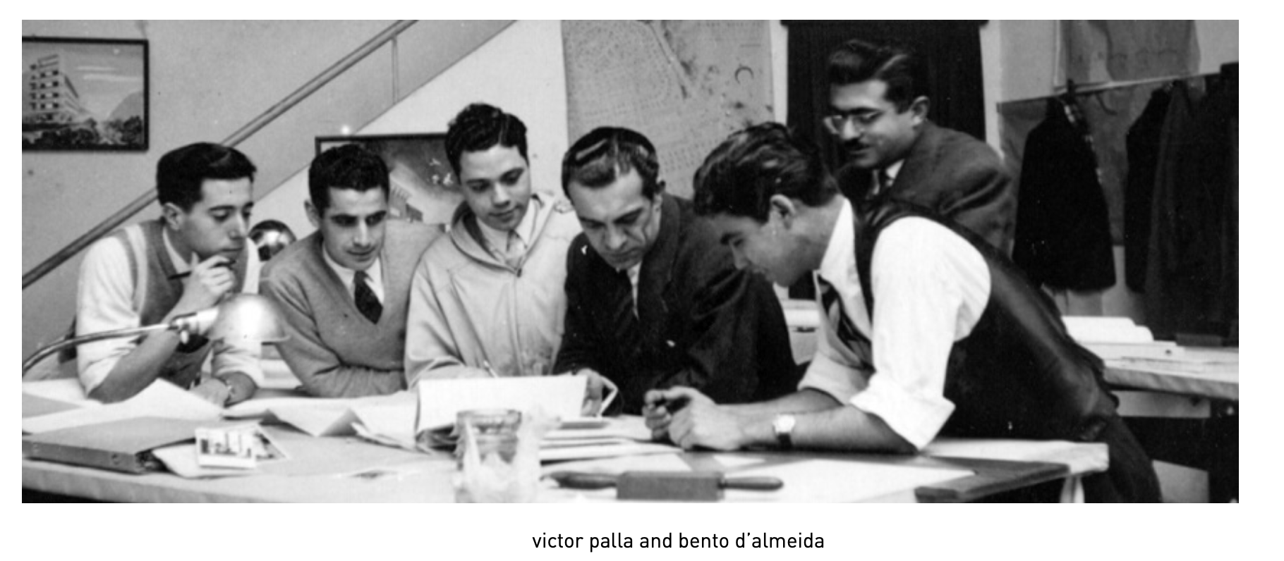 Architects Victor Palla and Bento d'Almeida reviewing plans at a drafting table