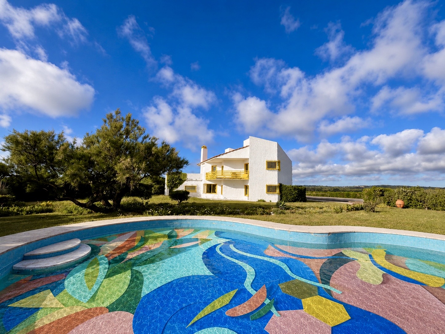 The white modernist house behind the colourful mosaic swimming pool at Ocean's Garden